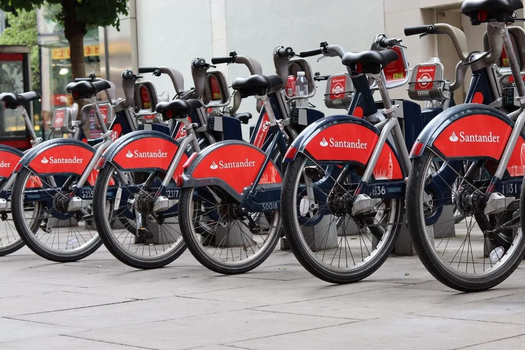 A row of Santander-branded rental bicycles parked at a docking station.