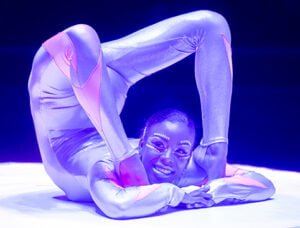 Contortionist performing in a lightsuit on stage.