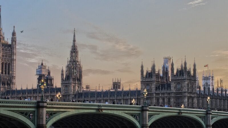 Westminster Palace and Big Ben at dusk with Westminster Bridge in the foreground.