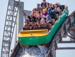 THORPE PARK Resort 2 People riding a log flume water ride, descending a steep drop, splashing water, and expressing excitement.
