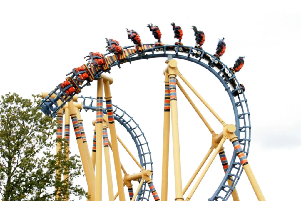 Discover the Joys of Flamingo Land in North Yorkshire 1 Kumali Roller coaster with blue tracks and beige supports featuring orange and black seats carrying riders through an inverted loop at flamingo land resort